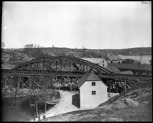 Danviksbro med Saltsjöbanan 1893 och Hospitalets byggnader i bakgrunden. Bilden är tagen mot norr, från sluttningen av Danviksklippen innan kanalen grävdes fram. Fotograf okänd. Stockholms stadsmuseum Fotonummer C 1235.