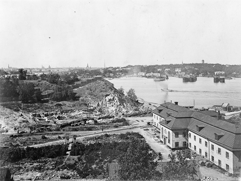 Här har nästan alla byggnader på hospitalsområdet rivits för att ge plats för kanalen som snart ska börja grävas. Bara kyrkobyggnaden, som idag står kvar, syns på bilden. Stadsmuseet i Stockholm 1917–1920. Fotograf okänd. Fa37529
