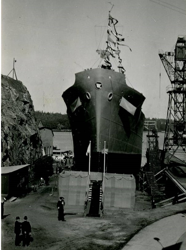 Fredrika sjösätts 1942 – just där Sjövägens båtar idag har sin tilläggsplats. Okänd fotograf. Statens maritima muséer. Huset där Foogia idag har sitt möbelvaruhus syns till vänster.