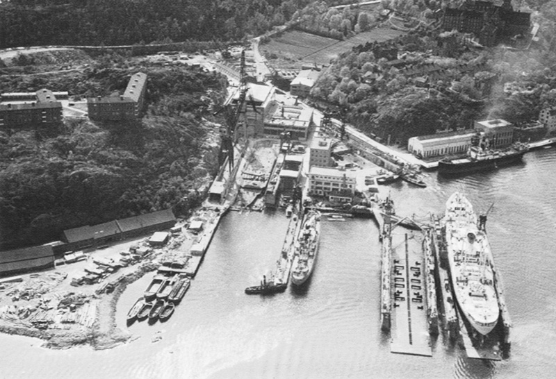 Finnberget i början av 1950-talet, till vänster, med de då nybyggda personalbostäderna. I flytdockan ligger fartyget M/S Birger Jarl. Den idag, delvis bevarade, stapelbädden syns i mitten av bilden. Fotograf Oscar Bladh. Stockholms stadsmuseum.