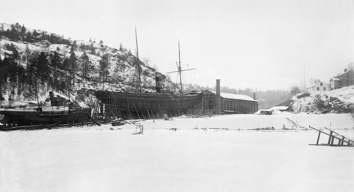 Ett tidigt foto från Finnboda slip. Årtal och fotograf okända. Sjöhistoriska muséet. Fo 3427. Den minsta vita byggnaden, på berget till höger, står kvar än idag i förfallet skick – snett emot livsmedelsbutiken.