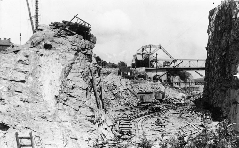 Här spränger man sig fram genom Danviksklippan 1923. I bakgrunden syns den då nya Danviksbron och till höger den delvis bortsprängda Danviksklippan. Fotograf Svenska Dagbladet. Stockholms stadsmuseum. Fotonummer Fa 40666