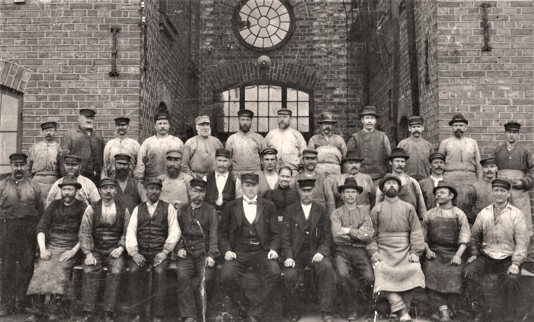 Oljefabrikens arbetare fotograferade på kajen framför fabriken på 1890-talet. Andre mannen i mittenraden från höger med ljus tröja under skjortan hette Gustav Carlsson. Det är hans sonson, Jörgen Arneving, som äger bilden.