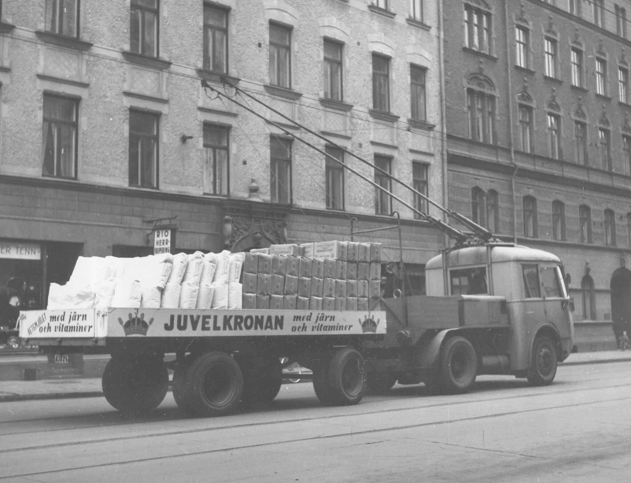 När bron till Kvarnholmen var byggd startade KF, strax före andra världskriget, en trådbusslinje till Södermalm. Några år senare började trådlastbilar köra mjölsäckar samma sträcka.. På 1970-talet övertog SL busstrafiken. Bilden från Folkungagatan runt 1950. Södermalms Foto. Nacka lokalhistoriska arkiv.