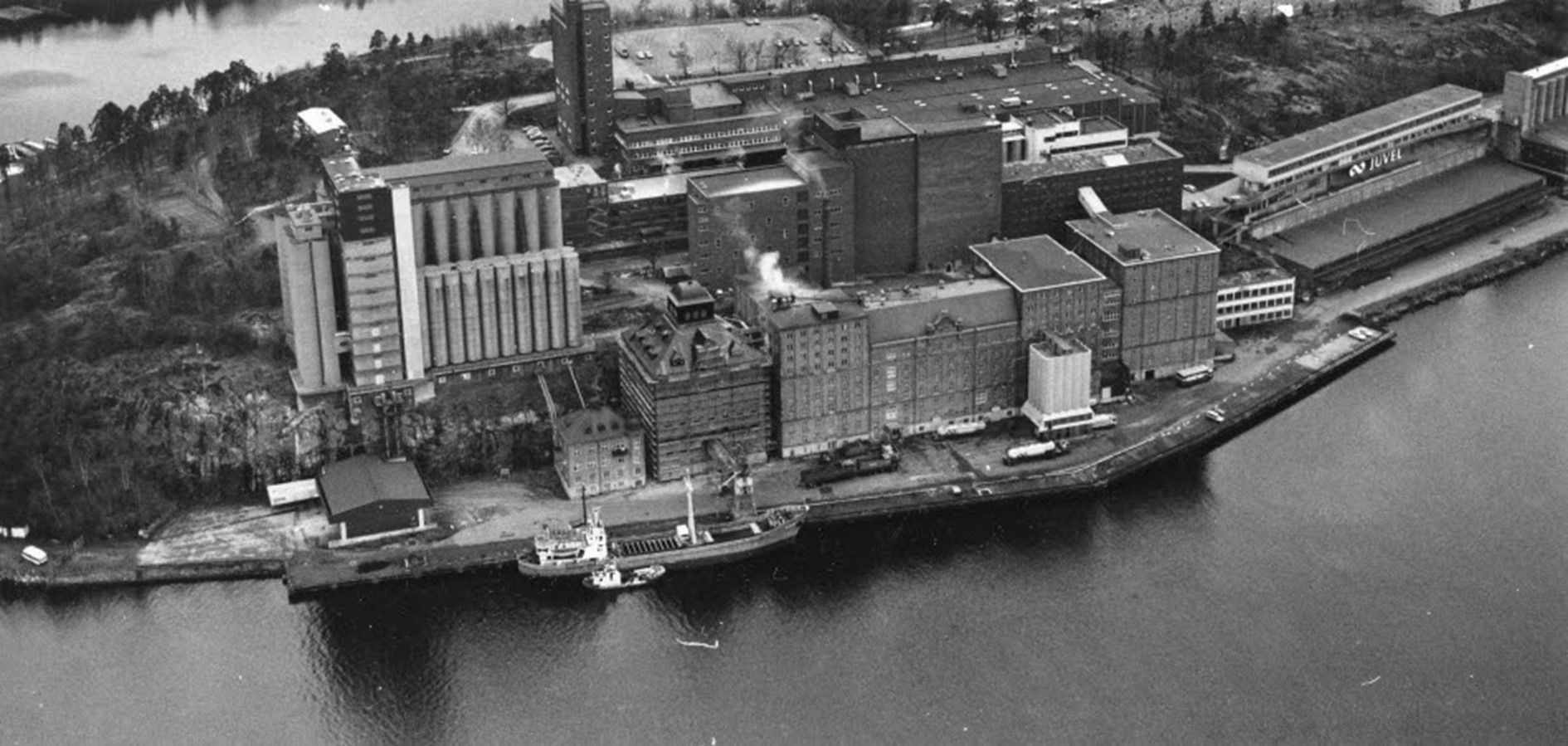 Till vänster syns nyare byggnader där arkitekten inte försökt dölja att det var silor i enlighet med de idéer som KF:s arkitektkontor drev tidigt. Foto Ingvar Lundkvist 1984. Nacka lokalhistoriska arkiv.