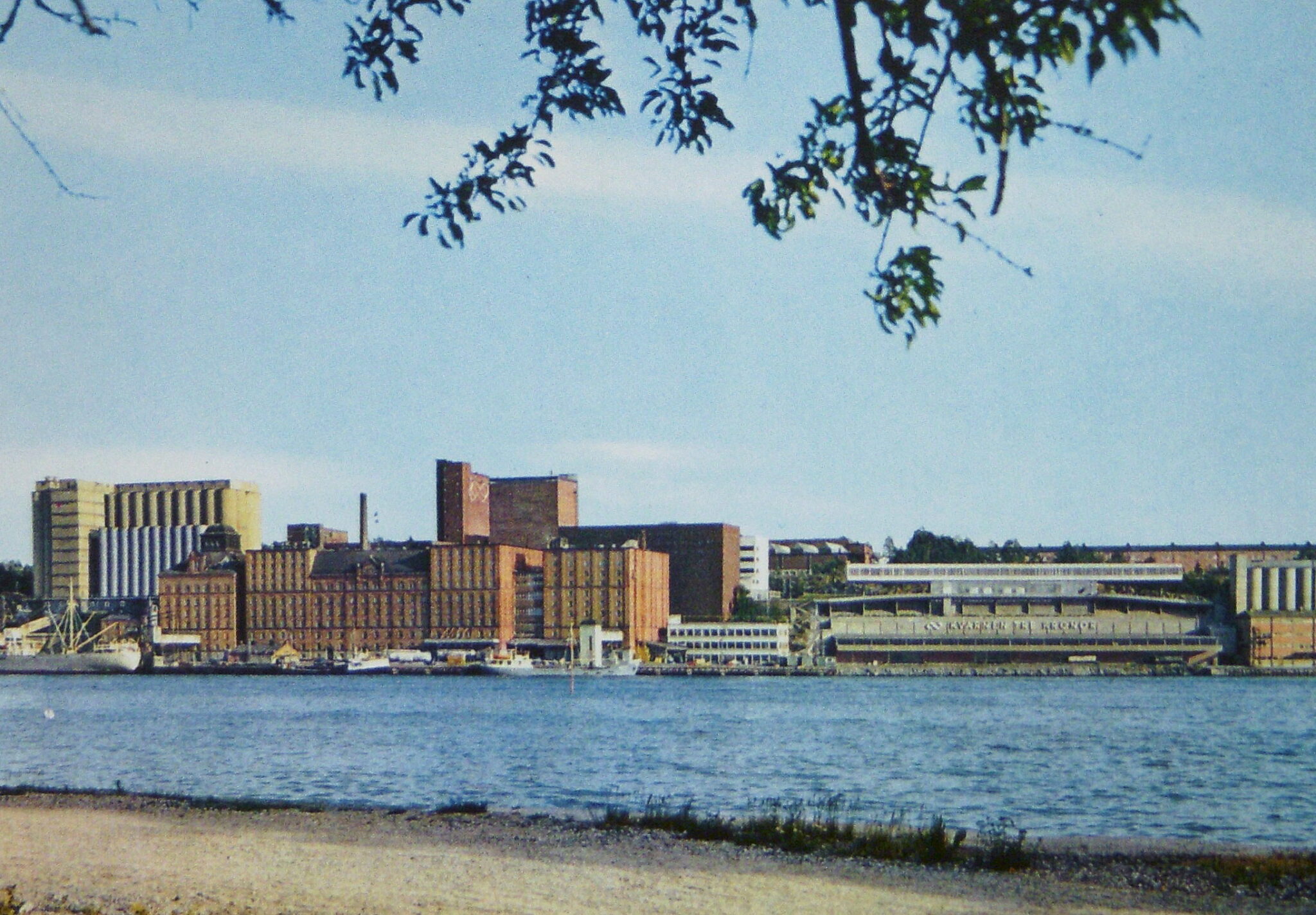 Kvarnholmen i sin glans dagar på 1950-talet. Munspelet svävar till höger. Vykort.