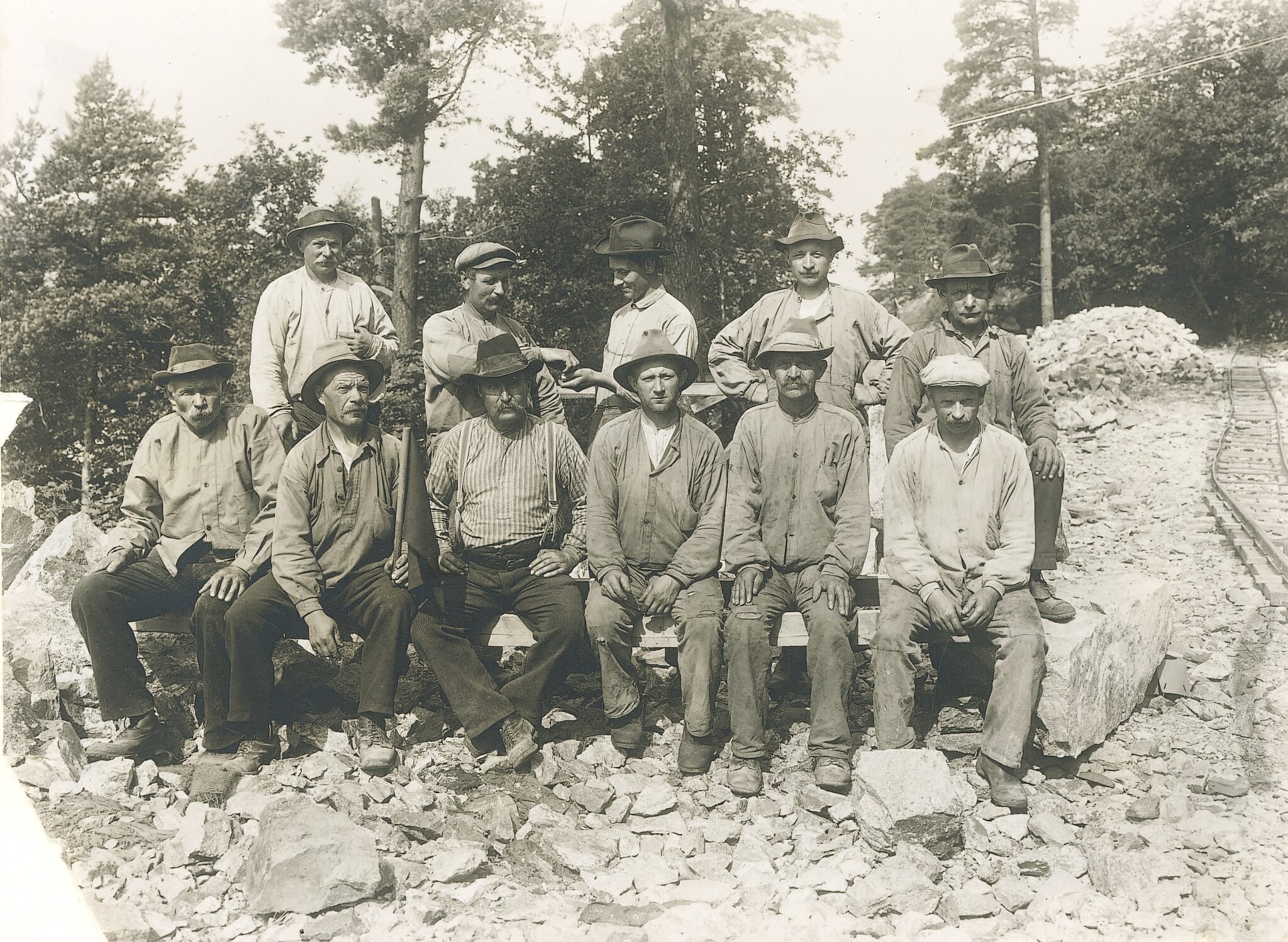 I början av 1900-talet byggde Superfosfatfabriken sex hus med arbetarbostäder för sina anställda. Här är arbetslaget. Fotograf okänd. Nacka lokalhistoriska arkiv.