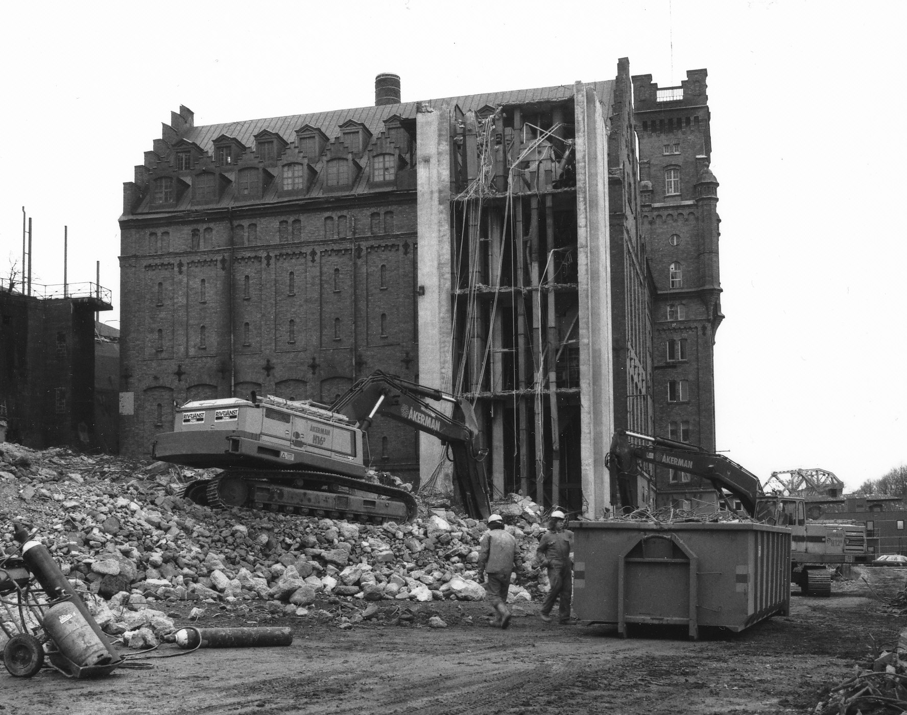 Betongsilor och maskintorn rivs. Foto efter 1990. Fotograf okänd. Nackas lokalhistoriska arkiv. 
